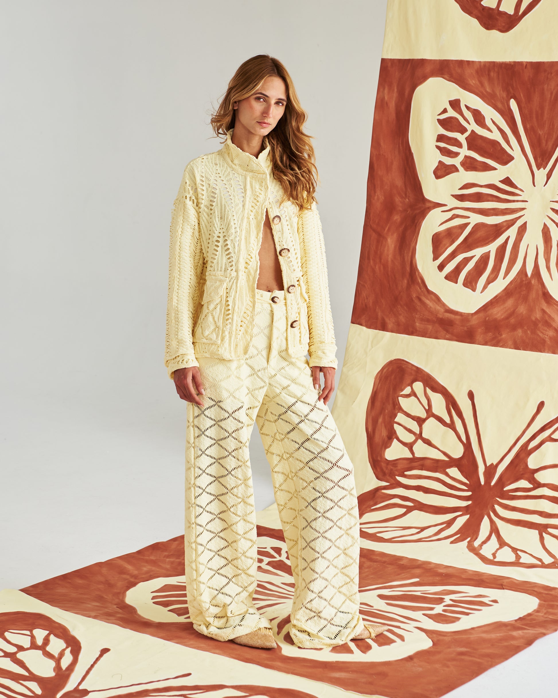 Chaqueta artesanal tejida a mano en tono arena, con detalles calados que la hacen ligera y sofisticada. Botones naturales y un corte relajado para un look fresco, cómodo y elegante. Perfecta para un estilo mediterráneo chic que te acompaña del día a la noche.&nbsp;
