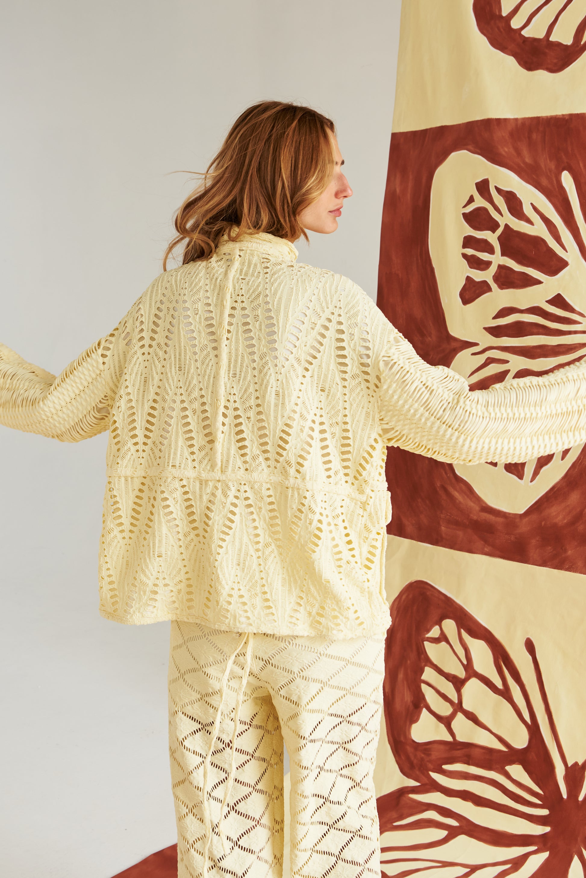 Chaqueta artesanal tejida a mano en tono arena, con detalles calados que la hacen ligera y sofisticada. Botones naturales y un corte relajado para un look fresco, cómodo y elegante. Perfecta para un estilo mediterráneo chic que te acompaña del día a la noche.&nbsp;